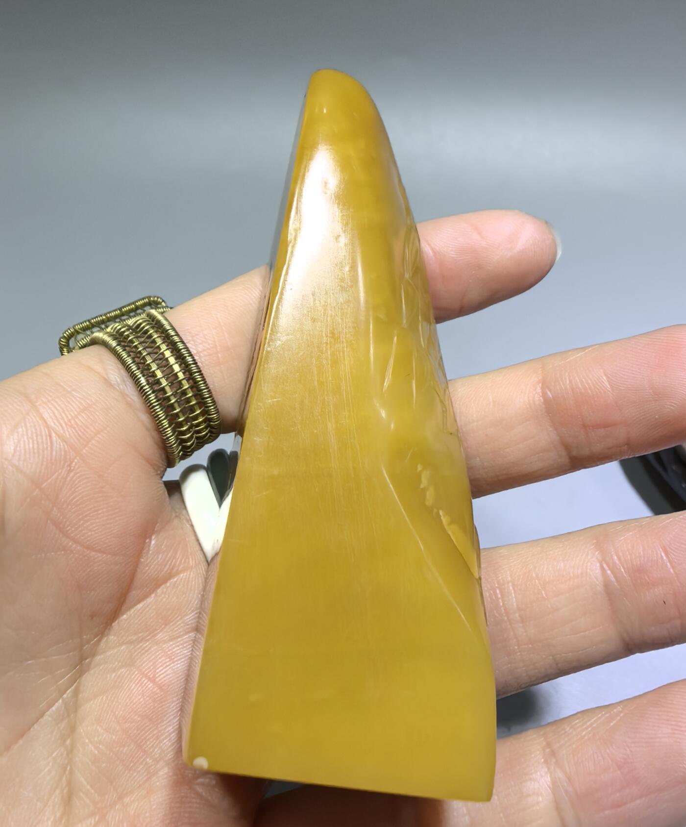 田黄石线雕印章
一两田黄十两金，市面上有“石帝”印石之王的美称。打灯肌理表皮组织可见密如之网的细萝卜纹，条理清晰。表皮可见一处天然裂格。博弈工，收藏级。尺寸:7.2cm*2.7cm克重:100.4g