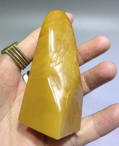 田黄石线雕印章
一两田黄十两金，市面上有“石帝”印石之王的美称。打灯肌理表皮组织可见密如之网的细萝卜纹，条理清晰。表皮可见一处天然裂格。博弈工，收藏级。尺寸:7.2cm*2.7cm克重:100.4g