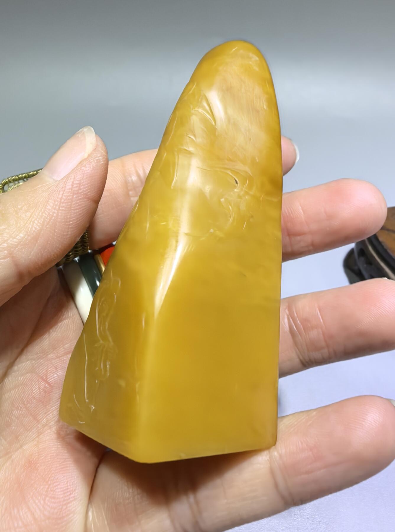 田黄石线雕印章
一两田黄十两金，市面上有“石帝”印石之王的美称。打灯肌理表皮组织可见密如之网的细萝卜纹，条理清晰。表皮可见一处天然裂格。博弈工，收藏级。尺寸:7.2cm*2.7cm克重:100.4g