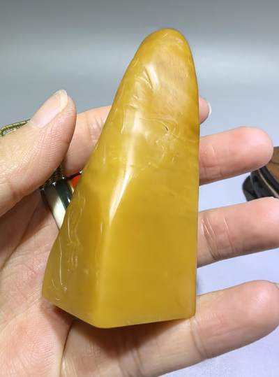 田黄石线雕印章
一两田黄十两金，市面上有“石帝”印石之王的美称。打灯肌理表皮组织可见密如之网的细萝卜纹，条理清晰。表皮可见一处天然裂格。博弈工，收藏级。尺寸:7.2cm*2.7cm克重:100.4g