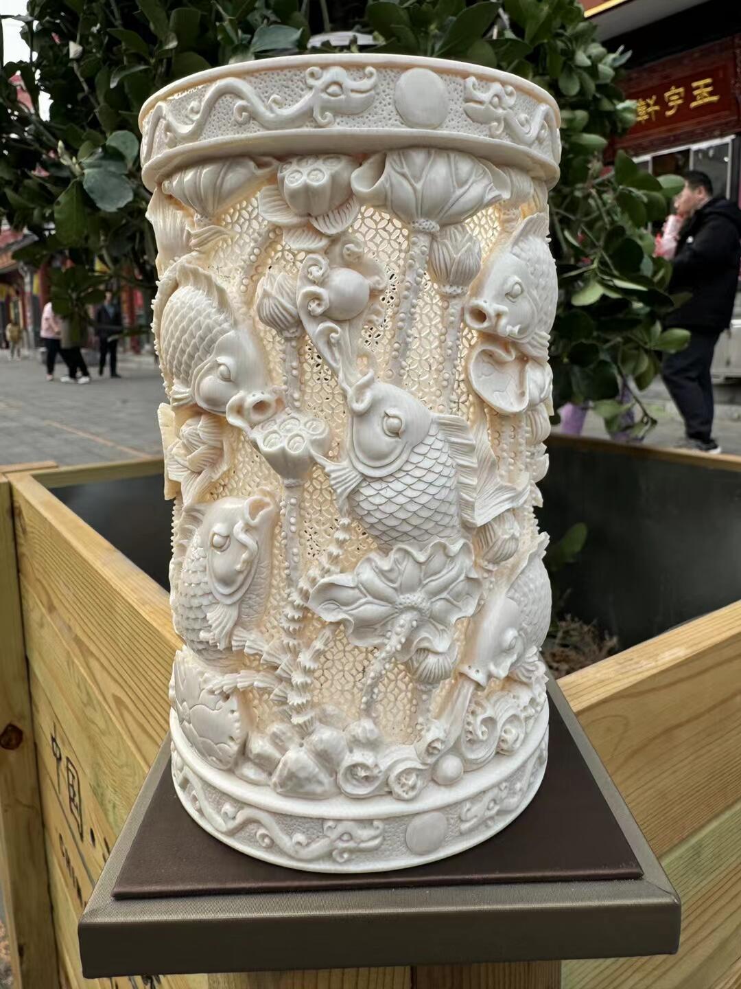 猛犸象牙大师手工雕刻《九鲤献福-连年有余》精品镂空笔筒，牙质油润，手工雕刻细节精致，活灵活现，流畅舒展。自古“九”就有长久之意，鱼谐“余”，寓意年年有余。送礼自藏皆为首选！尺寸：160×100mm 重量520克