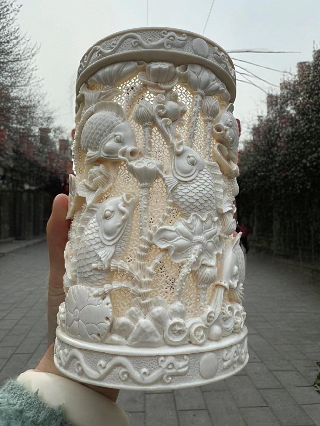 猛犸象牙大师手工雕刻《九鲤献福-连年有余》精品镂空笔筒，牙质油润，手工雕刻细节精致，活灵活现，流畅舒展。自古“九”就有长久之意，鱼谐“余”，寓意年年有余。送礼自藏皆为首选！尺寸：160×100mm 重量520克