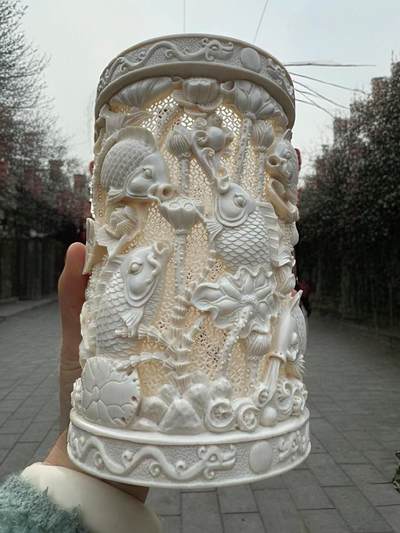 猛犸象牙大师手工雕刻《九鲤献福-连年有余》精品镂空笔筒，牙质油润，手工雕刻细节精致，活灵活现，流畅舒展。自古“九”就有长久之意，鱼谐“余”，寓意年年有余。送礼自藏皆为首选！尺寸：160×100mm 重量520克