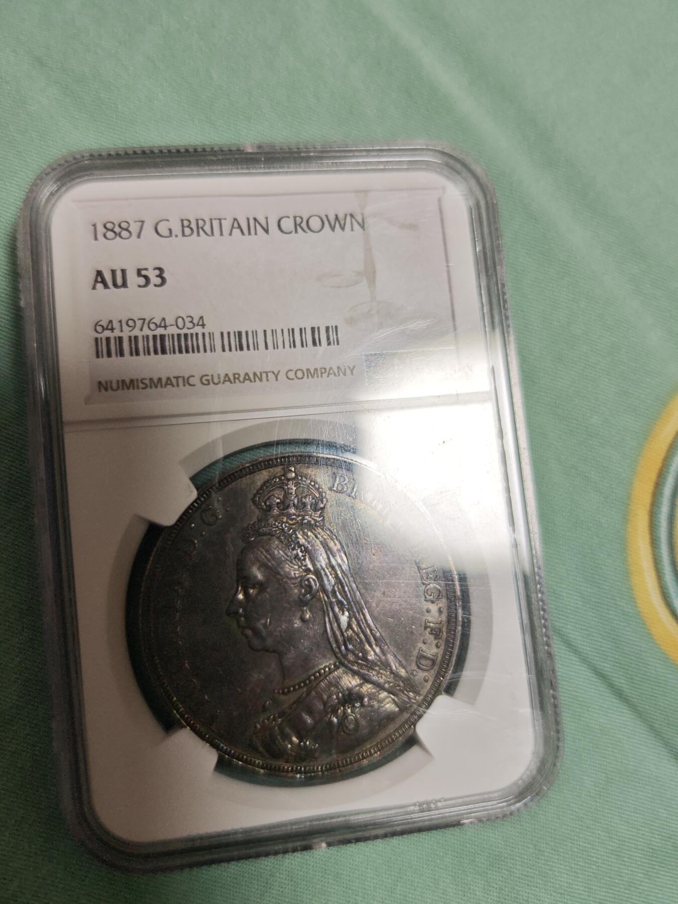 NGC AU53 黑丝入骨传世重黑油酱彩极品品相，大英帝国维多利亚女王高皇冠圣乔治骑士屠龙马剑大银元。状态极佳，字口全深打，人物细节拉满，气势十足，底板清爽干净，传世老黑油包浆醇熟入骨，明显低评压分的一枚大马剑老银元