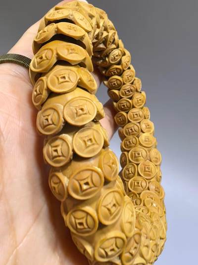 纯手工橄榄核财源滚滚，每颗挑选原籽为2.0cm以上精品核尖雕刻。宽1.7cm。