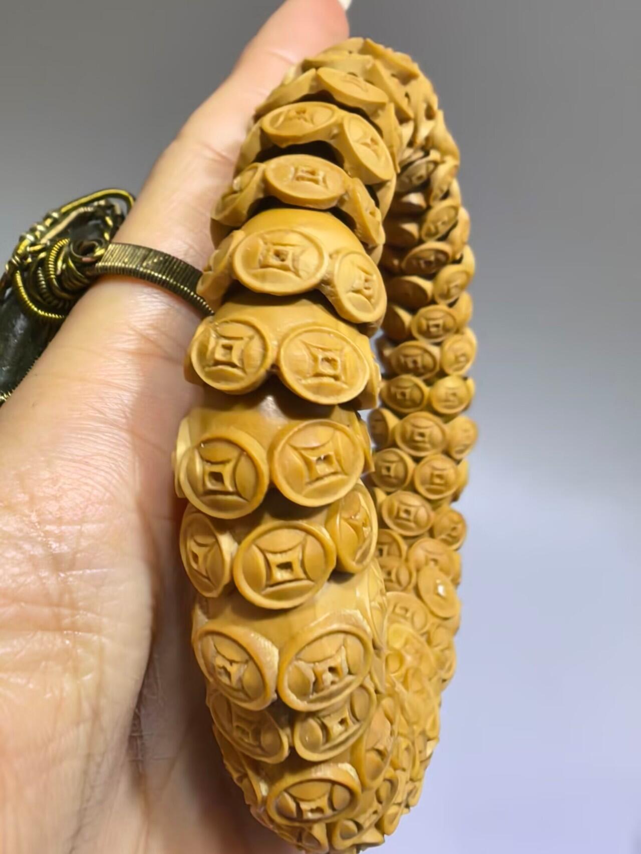 纯手工橄榄核财源滚滚，每颗挑选原籽为2.0cm以上精品核尖雕刻。宽1.7cm。