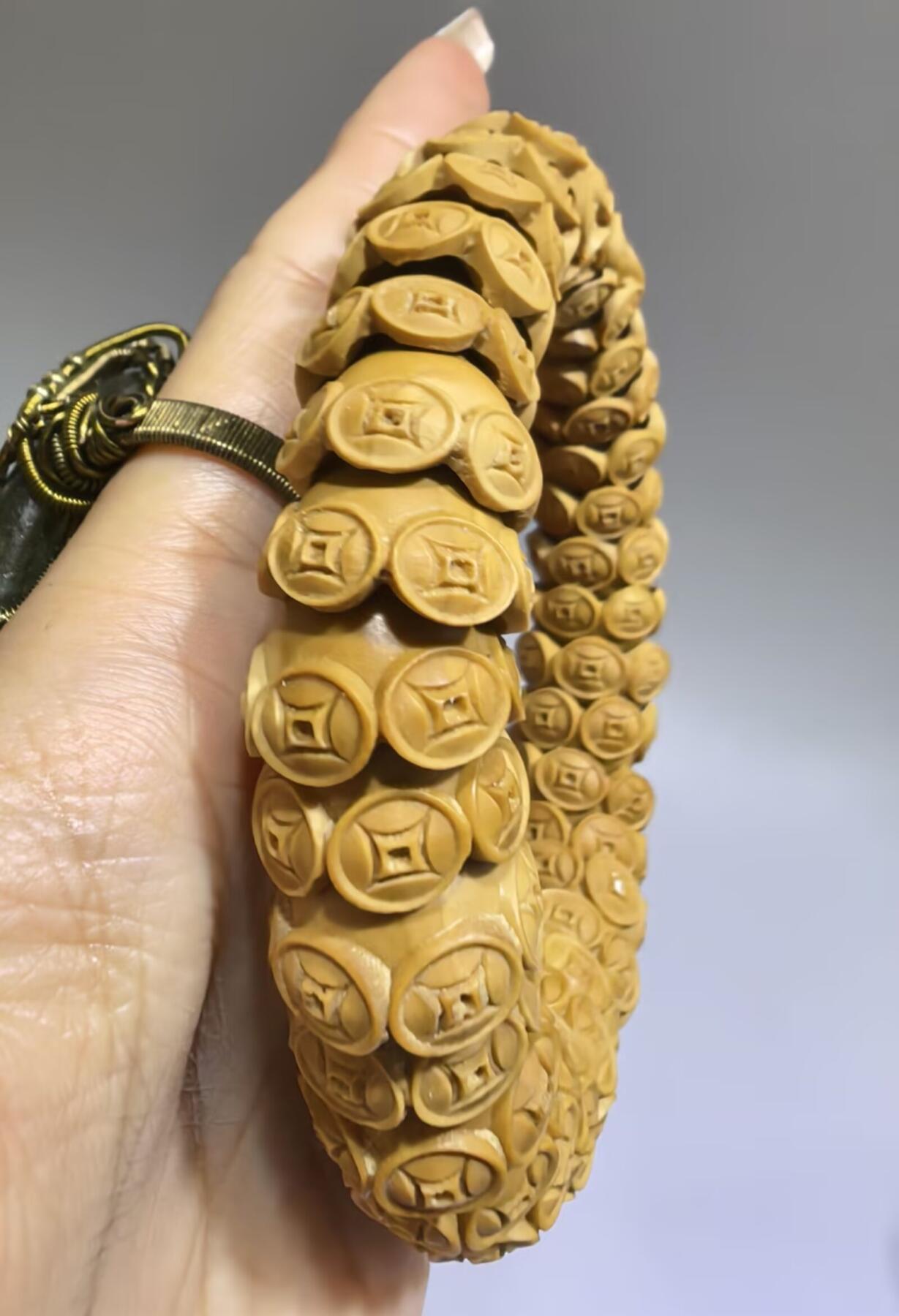 纯手工橄榄核财源滚滚，每颗挑选原籽为2.0cm以上精品核尖雕刻。宽1.7cm。