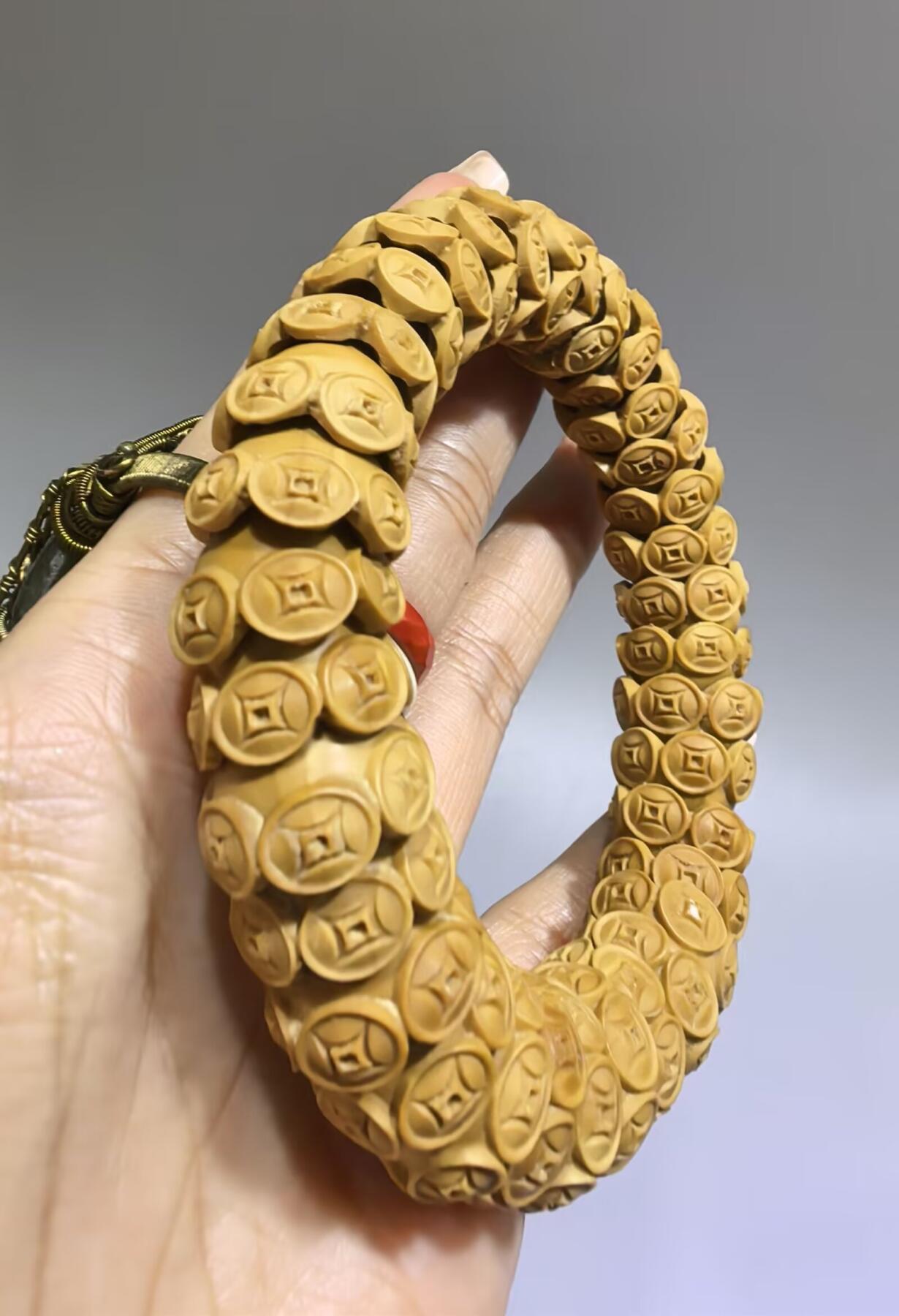 纯手工橄榄核财源滚滚，每颗挑选原籽为2.0cm以上精品核尖雕刻。宽1.7cm。