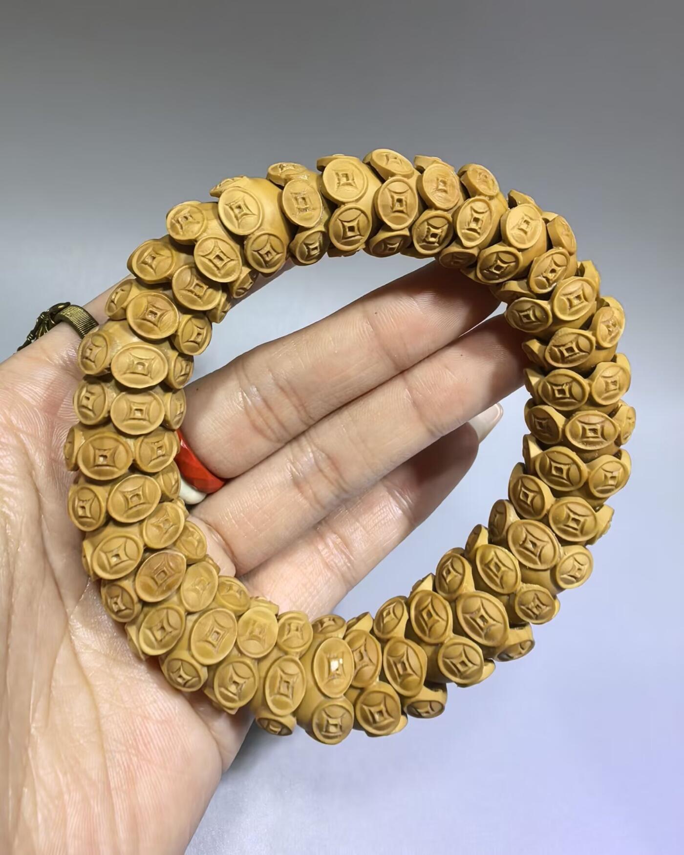 纯手工橄榄核财源滚滚，每颗挑选原籽为2.0cm以上精品核尖雕刻。宽1.7cm。