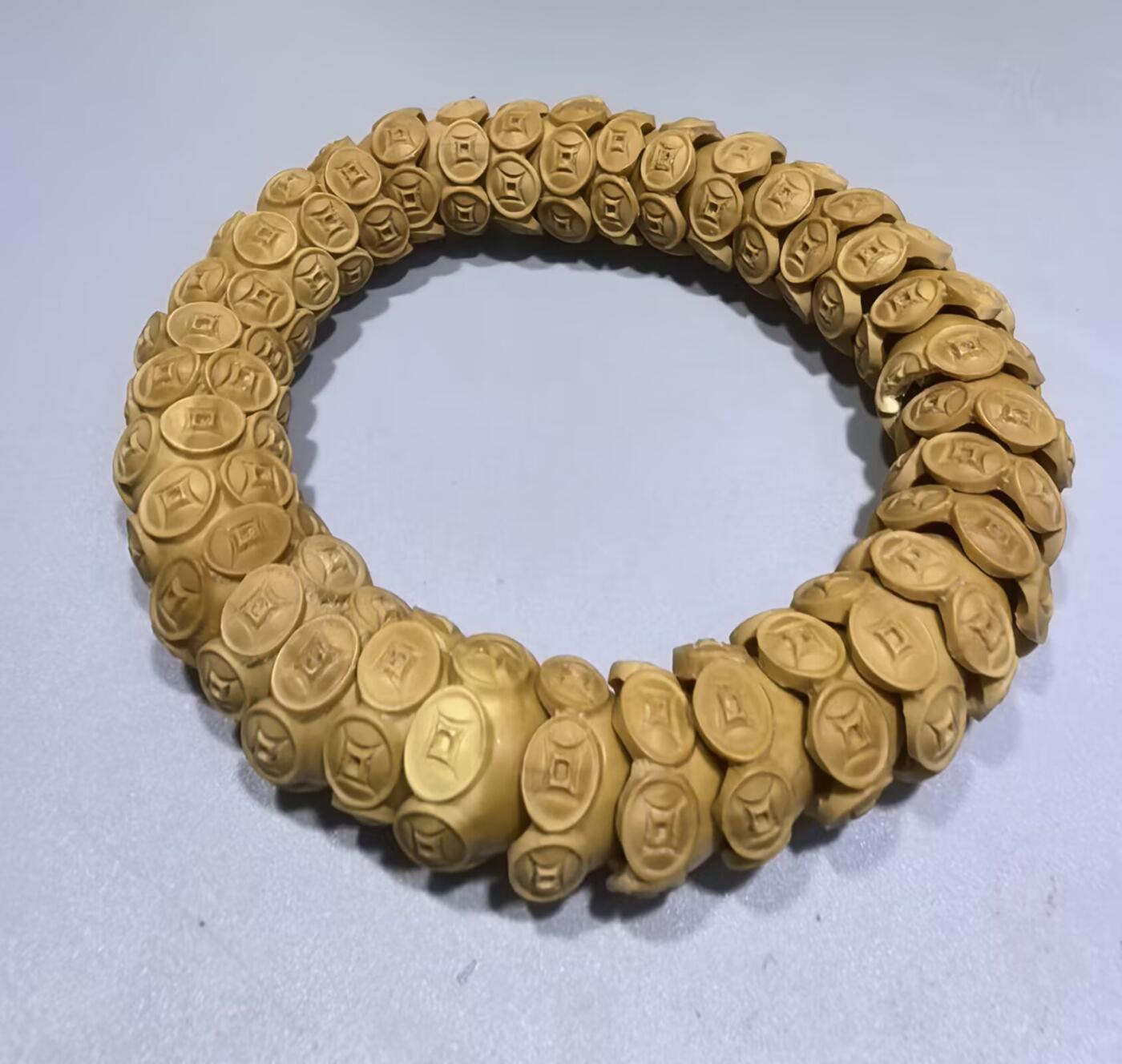 纯手工橄榄核财源滚滚，每颗挑选原籽为2.0cm以上精品核尖雕刻。宽1.7cm。