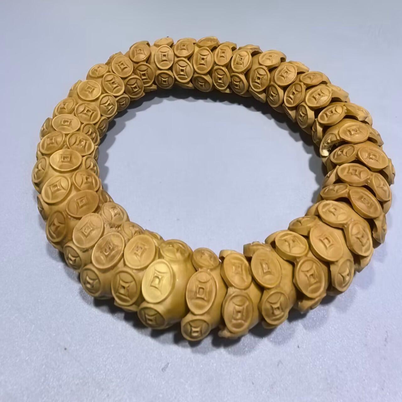 纯手工橄榄核财源滚滚，每颗挑选原籽为2.0cm以上精品核尖雕刻。宽1.7cm。