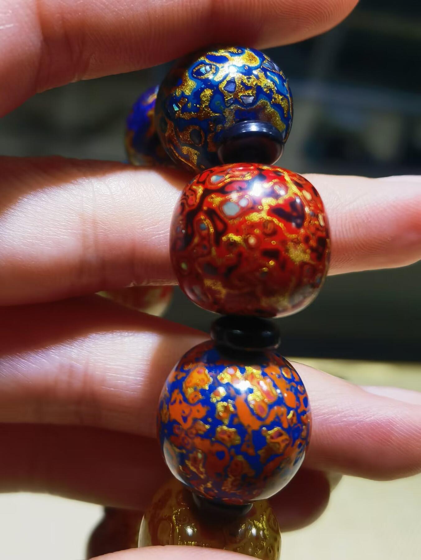 非遗大漆满螺钿手串鼓珠，甄选天然材质，匠心工艺，它是一种树脂涂料，生长条件严苛，成熟缓慢，漆树需生长10年才能割采，一颗漆树整个生命周期只能割出10公斤生漆，3000颗漆树采集一公斤生漆，有“百里千刀一斤漆”的说法，收集完后过滤提取成为优良大漆，它耐酸、耐潮、耐高温，天然环保。大漆工艺是一种表面涂漆，并以彩绘，雕刻加以美化，利用不同的色彩，不同的空间对比以及映照营造出立体的视觉美感的手工艺术。