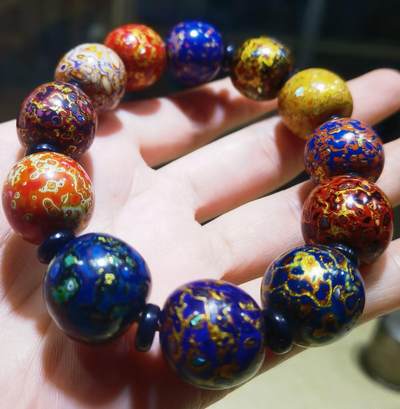 非遗大漆满螺钿手串鼓珠，甄选天然材质，匠心工艺，它是一种树脂涂料，生长条件严苛，成熟缓慢，漆树需生长10年才能割采，一颗漆树整个生命周期只能割出10公斤生漆，3000颗漆树采集一公斤生漆，有“百里千刀一斤漆”的说法，收集完后过滤提取成为优良大漆，它耐酸、耐潮、耐高温，天然环保。大漆工艺是一种表面涂漆，并以彩绘，雕刻加以美化，利用不同的色彩，不同的空间对比以及映照营造出立体的视觉美感的手工艺术。