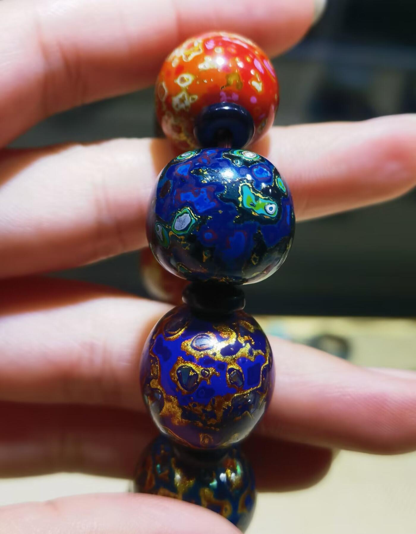 非遗大漆满螺钿手串鼓珠，甄选天然材质，匠心工艺，它是一种树脂涂料，生长条件严苛，成熟缓慢，漆树需生长10年才能割采，一颗漆树整个生命周期只能割出10公斤生漆，3000颗漆树采集一公斤生漆，有“百里千刀一斤漆”的说法，收集完后过滤提取成为优良大漆，它耐酸、耐潮、耐高温，天然环保。大漆工艺是一种表面涂漆，并以彩绘，雕刻加以美化，利用不同的色彩，不同的空间对比以及映照营造出立体的视觉美感的手工艺术。