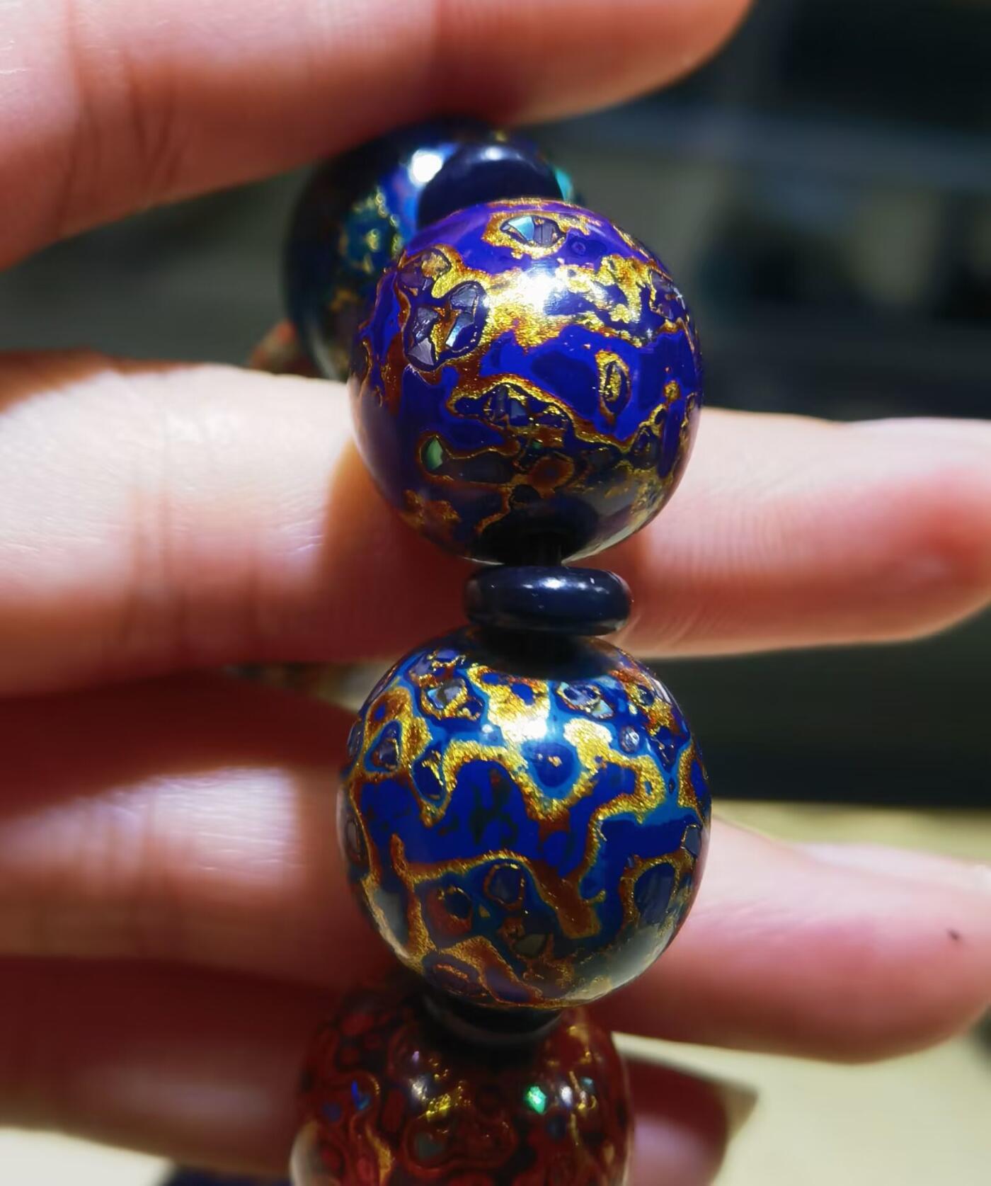 非遗大漆满螺钿手串鼓珠，甄选天然材质，匠心工艺，它是一种树脂涂料，生长条件严苛，成熟缓慢，漆树需生长10年才能割采，一颗漆树整个生命周期只能割出10公斤生漆，3000颗漆树采集一公斤生漆，有“百里千刀一斤漆”的说法，收集完后过滤提取成为优良大漆，它耐酸、耐潮、耐高温，天然环保。大漆工艺是一种表面涂漆，并以彩绘，雕刻加以美化，利用不同的色彩，不同的空间对比以及映照营造出立体的视觉美感的手工艺术。