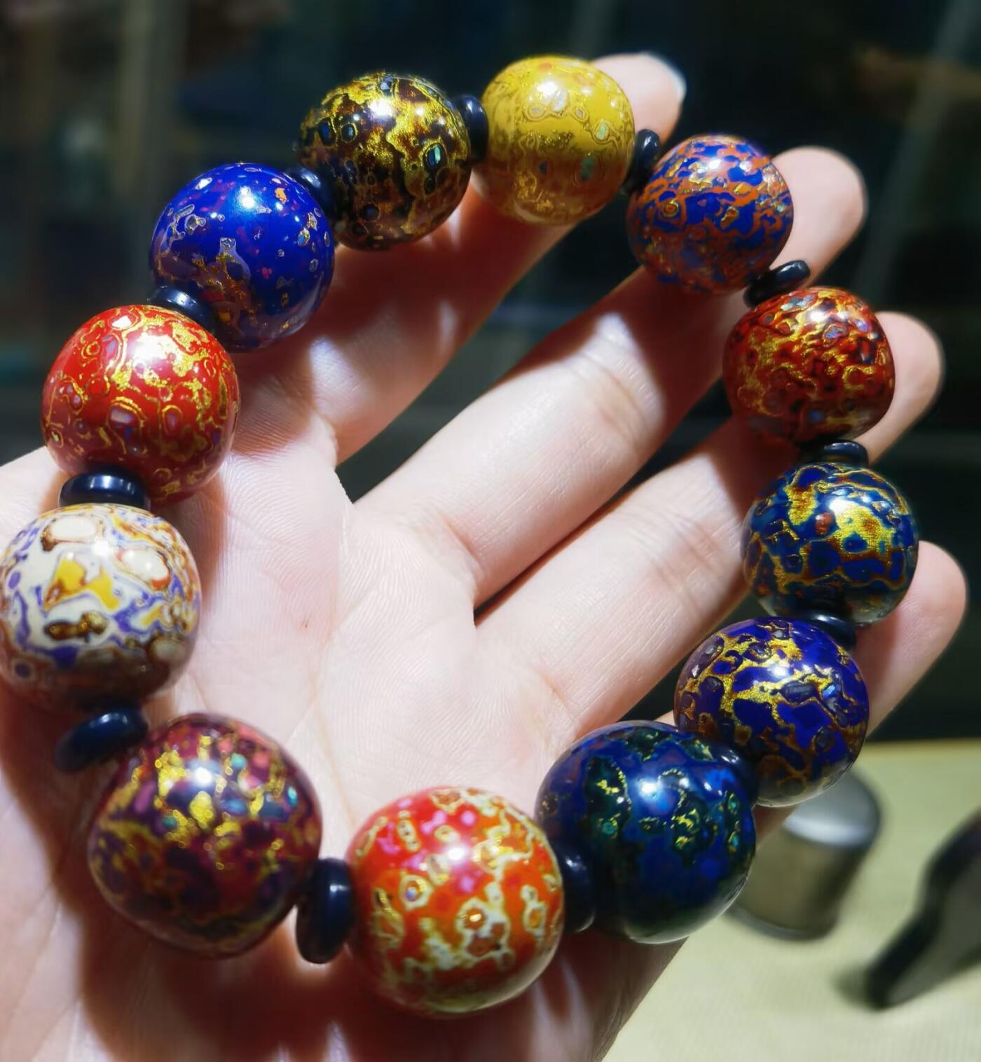 非遗大漆满螺钿手串鼓珠，甄选天然材质，匠心工艺，它是一种树脂涂料，生长条件严苛，成熟缓慢，漆树需生长10年才能割采，一颗漆树整个生命周期只能割出10公斤生漆，3000颗漆树采集一公斤生漆，有“百里千刀一斤漆”的说法，收集完后过滤提取成为优良大漆，它耐酸、耐潮、耐高温，天然环保。大漆工艺是一种表面涂漆，并以彩绘，雕刻加以美化，利用不同的色彩，不同的空间对比以及映照营造出立体的视觉美感的手工艺术。