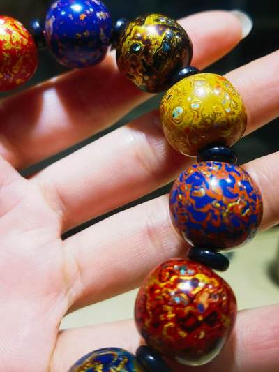 非遗大漆满螺钿手串鼓珠，甄选天然材质，匠心工艺，它是一种树脂涂料，生长条件严苛，成熟缓慢，漆树需生长10年才能割采，一颗漆树整个生命周期只能割出10公斤生漆，3000颗漆树采集一公斤生漆，有“百里千刀一斤漆”的说法，收集完后过滤提取成为优良大漆，它耐酸、耐潮、耐高温，天然环保。大漆工艺是一种表面涂漆，并以彩绘，雕刻加以美化，利用不同的色彩，不同的空间对比以及映照营造出立体的视觉美感的手工艺术。