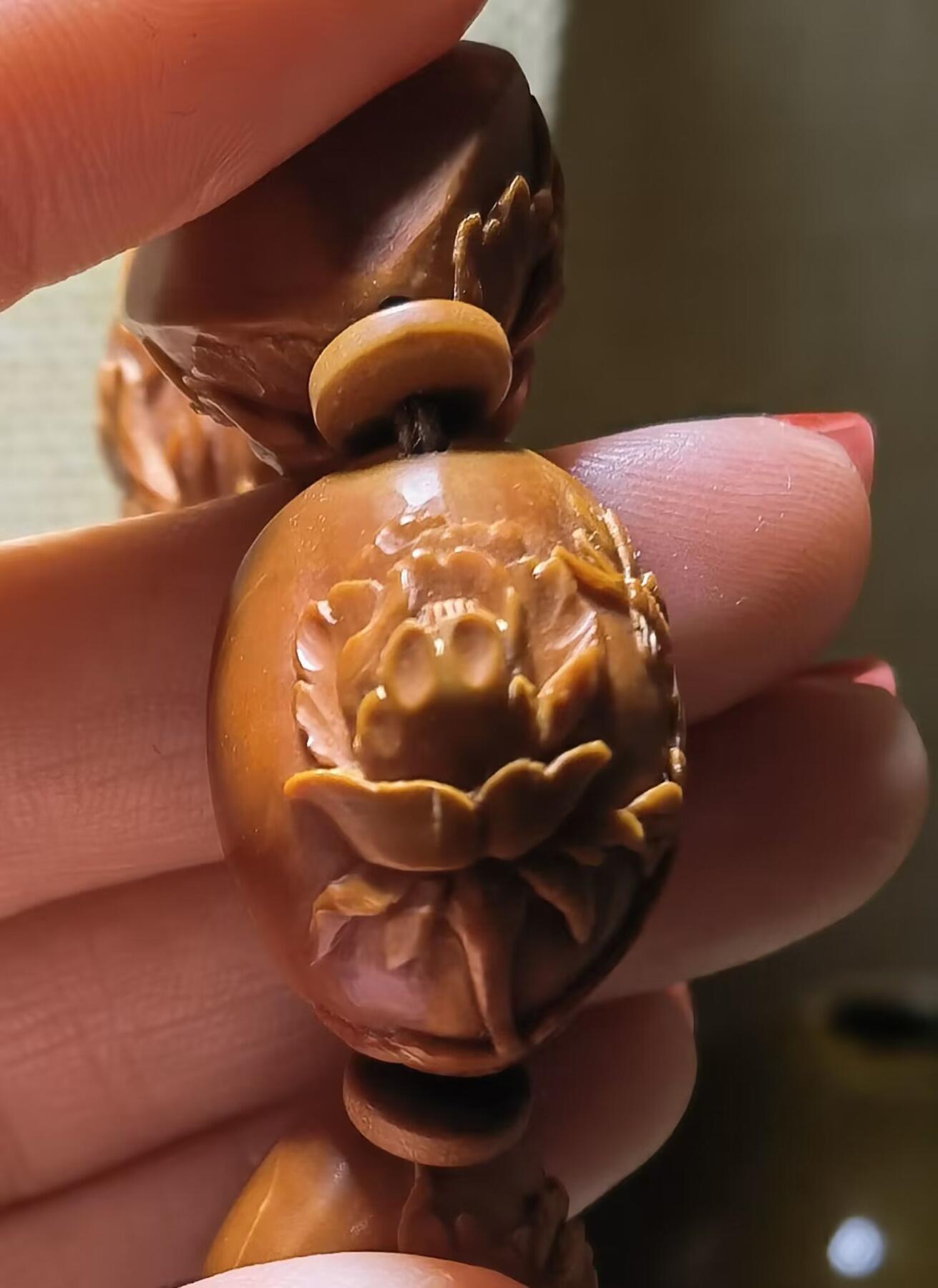 纯手工橄榄核浮雕凤穿牡丹男款手串佛珠，三花扁核浮雕凤穿牡丹花瓣雕刻栩栩如生，花瓣花蕊清晰渐层，扁核需要在不同面连贯雕刻，考验雕刻师的雕刻技术可见清晰留刀痕尺寸：18宽mm*24长mm