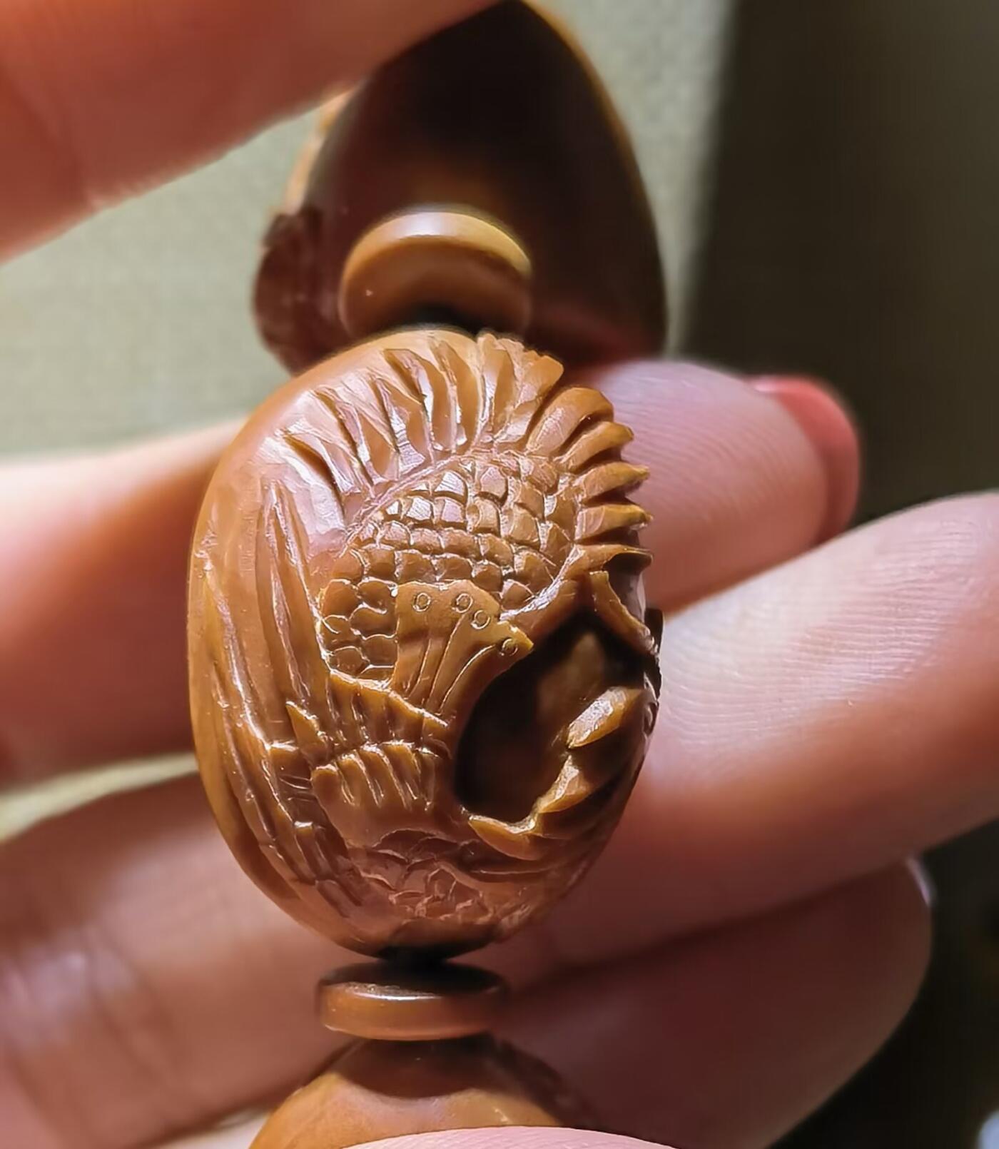 纯手工橄榄核浮雕凤穿牡丹男款手串佛珠，三花扁核浮雕凤穿牡丹花瓣雕刻栩栩如生，花瓣花蕊清晰渐层，扁核需要在不同面连贯雕刻，考验雕刻师的雕刻技术可见清晰留刀痕尺寸：18宽mm*24长mm