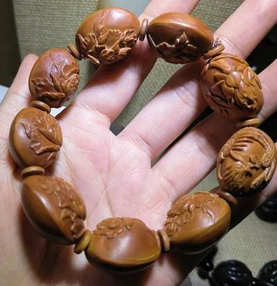 纯手工橄榄核浮雕凤穿牡丹男款手串佛珠，三花扁核浮雕凤穿牡丹花瓣雕刻栩栩如生，花瓣花蕊清晰渐层，扁核需要在不同面连贯雕刻，考验雕刻师的雕刻技术可见清晰留刀痕尺寸：18宽mm*24长mm