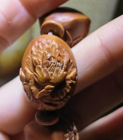纯手工橄榄核浮雕凤穿牡丹男款手串佛珠，三花扁核浮雕凤穿牡丹花瓣雕刻栩栩如生，花瓣花蕊清晰渐层，扁核需要在不同面连贯雕刻，考验雕刻师的雕刻技术可见清晰留刀痕尺寸：18宽mm*24长mm