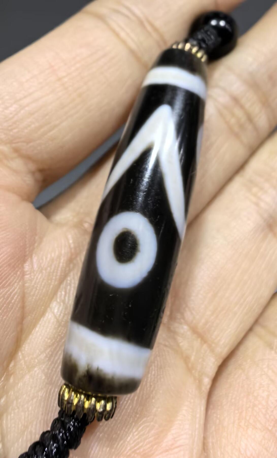 聚源四眼天珠项链锁骨链吊坠挂件男女款，咬线分明，黑白线条有明显的分界线，胎脂比较油润，此款四眼天珠属于特殊图腾的四眼天珠。市面比较少见，纯手工珠。