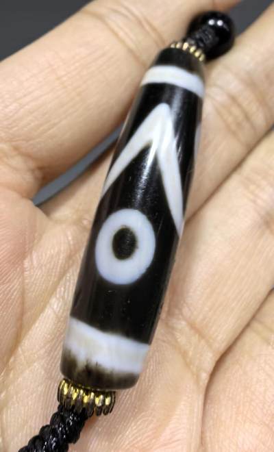 聚源四眼天珠项链锁骨链吊坠挂件男女款，咬线分明，黑白线条有明显的分界线，胎脂比较油润，此款四眼天珠属于特殊图腾的四眼天珠。市面比较少见，纯手工珠。