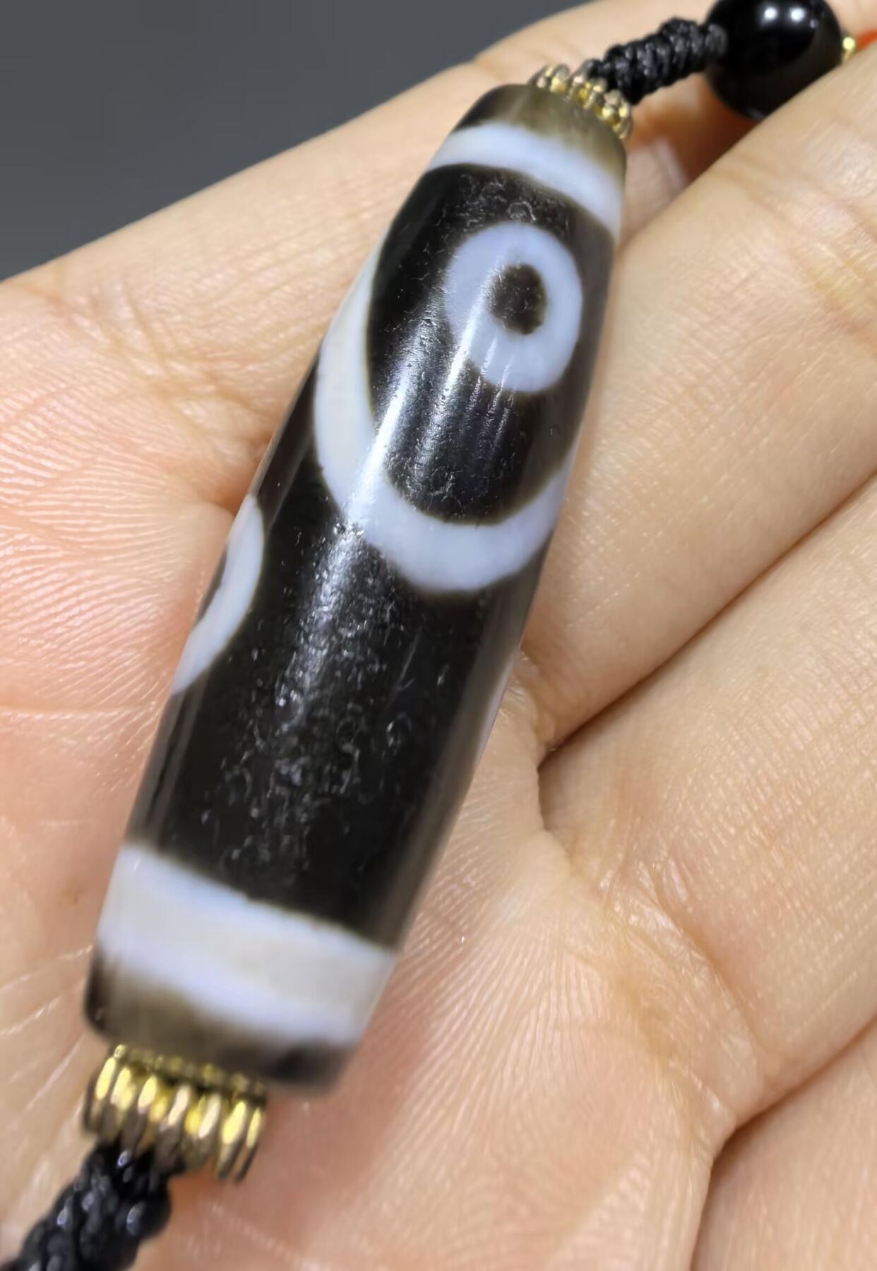 聚源四眼天珠项链锁骨链吊坠挂件男女款，咬线分明，黑白线条有明显的分界线，胎脂比较油润，此款四眼天珠属于特殊图腾的四眼天珠。市面比较少见，纯手工珠。