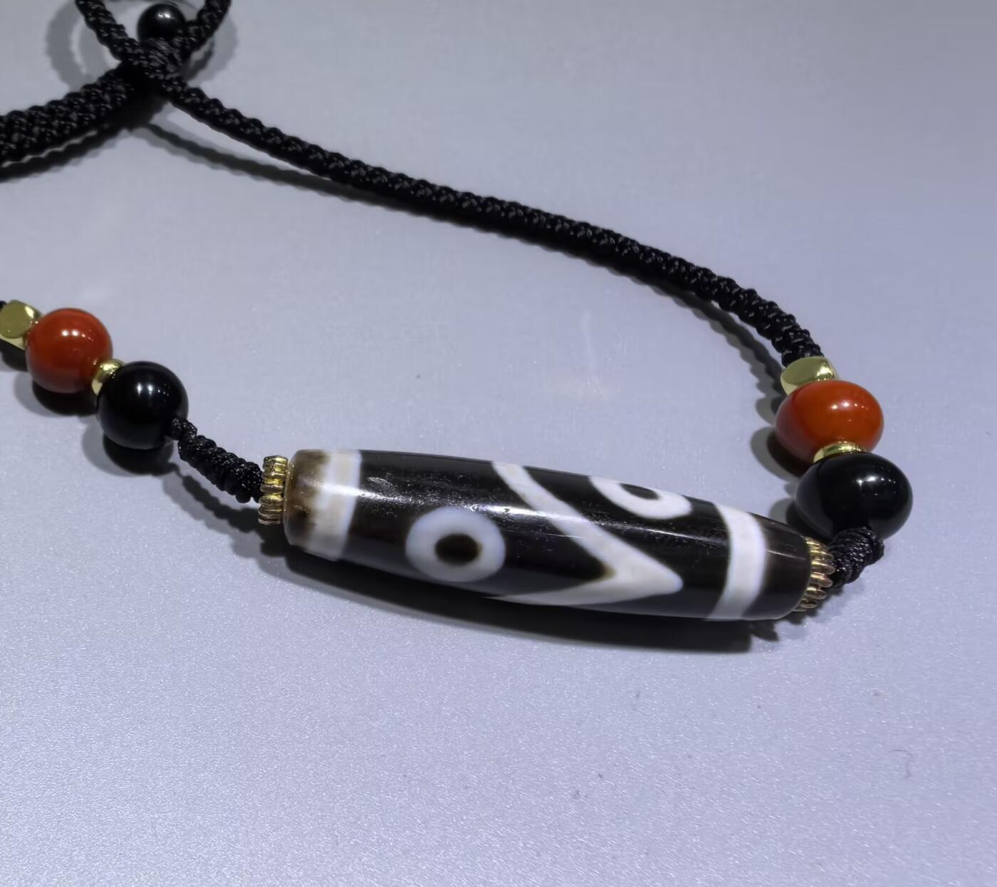 聚源四眼天珠项链锁骨链吊坠挂件男女款，咬线分明，黑白线条有明显的分界线，胎脂比较油润，此款四眼天珠属于特殊图腾的四眼天珠。市面比较少见，纯手工珠。