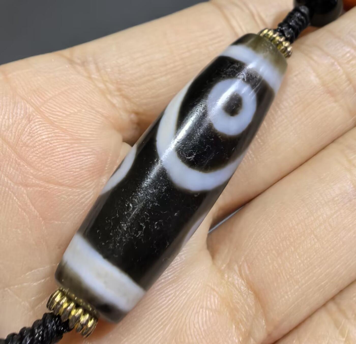 聚源四眼天珠项链锁骨链吊坠挂件男女款，咬线分明，黑白线条有明显的分界线，胎脂比较油润，此款四眼天珠属于特殊图腾的四眼天珠。市面比较少见，纯手工珠。