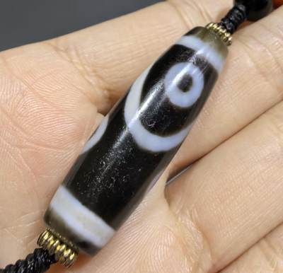 聚源四眼天珠项链锁骨链吊坠挂件男女款，咬线分明，黑白线条有明显的分界线，胎脂比较油润，此款四眼天珠属于特殊图腾的四眼天珠。市面比较少见，纯手工珠。