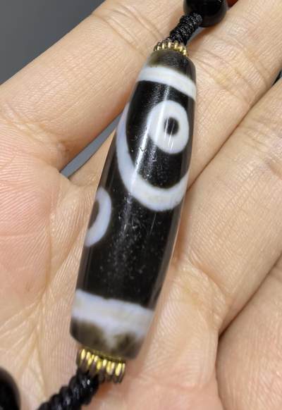 聚源四眼天珠项链锁骨链吊坠挂件男女款，咬线分明，黑白线条有明显的分界线，胎脂比较油润，此款四眼天珠属于特殊图腾的四眼天珠。市面比较少见，纯手工珠。