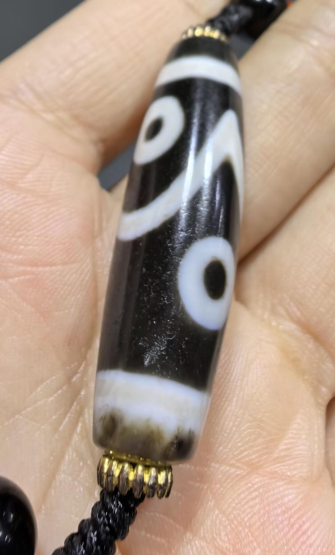 聚源四眼天珠项链锁骨链吊坠挂件男女款，咬线分明，黑白线条有明显的分界线，胎脂比较油润，此款四眼天珠属于特殊图腾的四眼天珠。市面比较少见，纯手工珠。