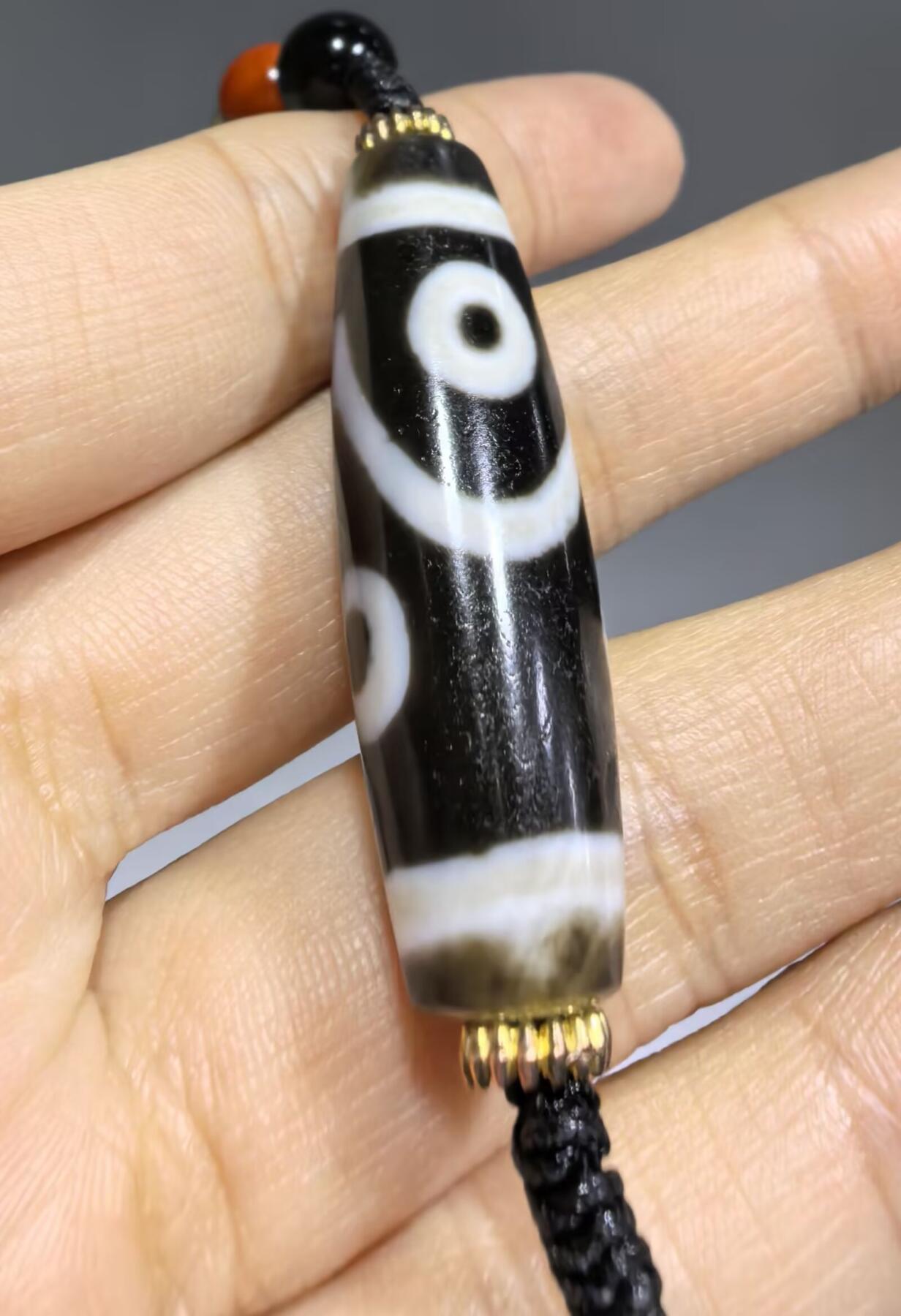 聚源四眼天珠项链锁骨链吊坠挂件男女款，咬线分明，黑白线条有明显的分界线，胎脂比较油润，此款四眼天珠属于特殊图腾的四眼天珠。市面比较少见，纯手工珠。