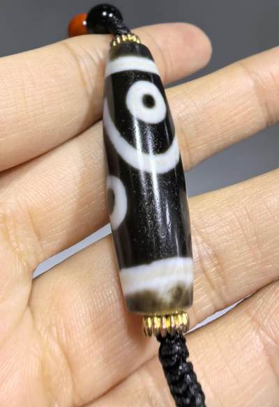 聚源四眼天珠项链锁骨链吊坠挂件男女款，咬线分明，黑白线条有明显的分界线，胎脂比较油润，此款四眼天珠属于特殊图腾的四眼天珠。市面比较少见，纯手工珠。