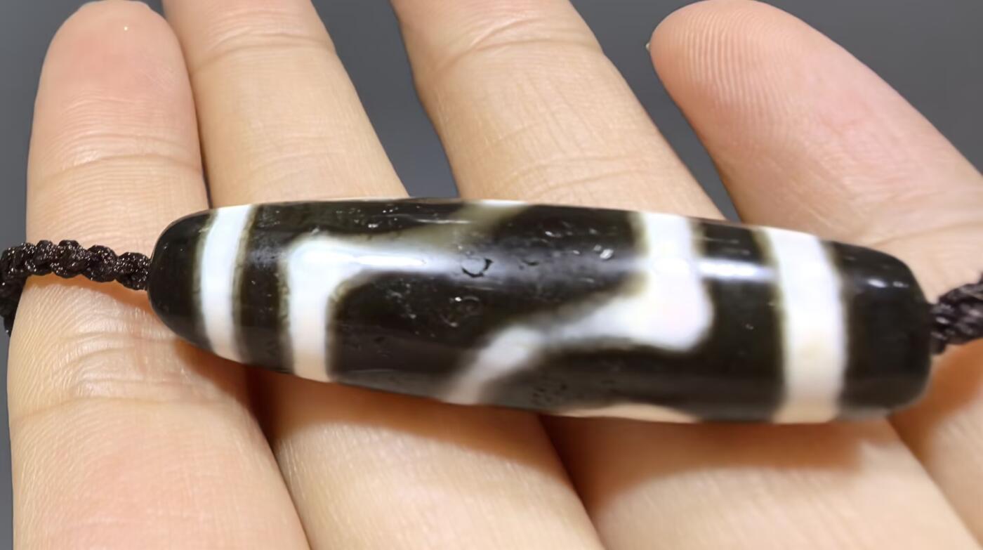 清末民国二眼天珠项链清末民国二眼天珠
此款二眼天珠是小年份大清至民国。可见明显的岁月包浆痕迹，珠体有明显的油沁，这是由于长时间佩戴，人体的油脂已经渗透到玛瑙里，产生了灰沁。
​尺寸:3.8*1.1cm
​