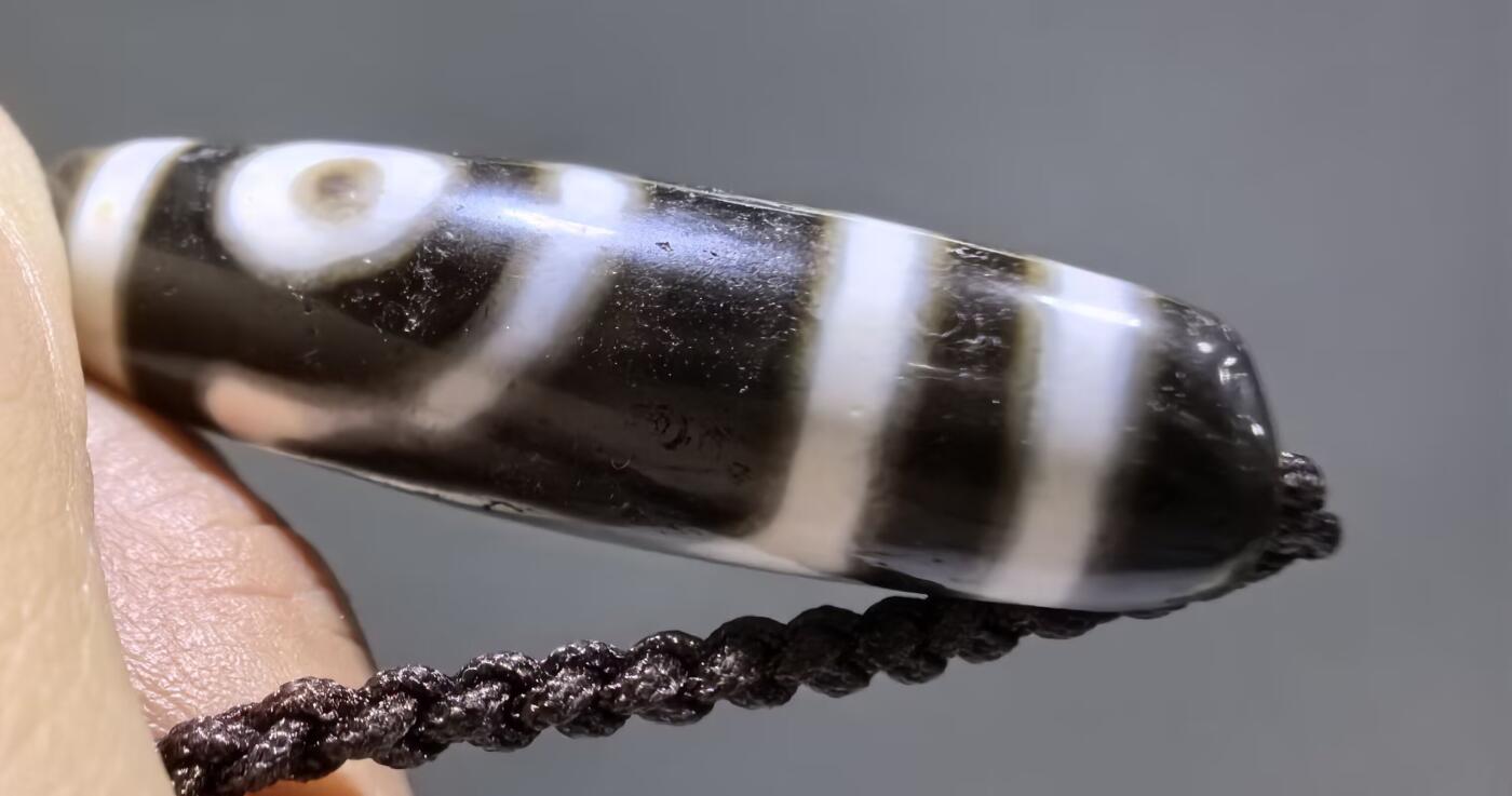 清末民国二眼天珠项链清末民国二眼天珠
此款二眼天珠是小年份大清至民国。可见明显的岁月包浆痕迹，珠体有明显的油沁，这是由于长时间佩戴，人体的油脂已经渗透到玛瑙里，产生了灰沁。
​尺寸:3.8*1.1cm
​