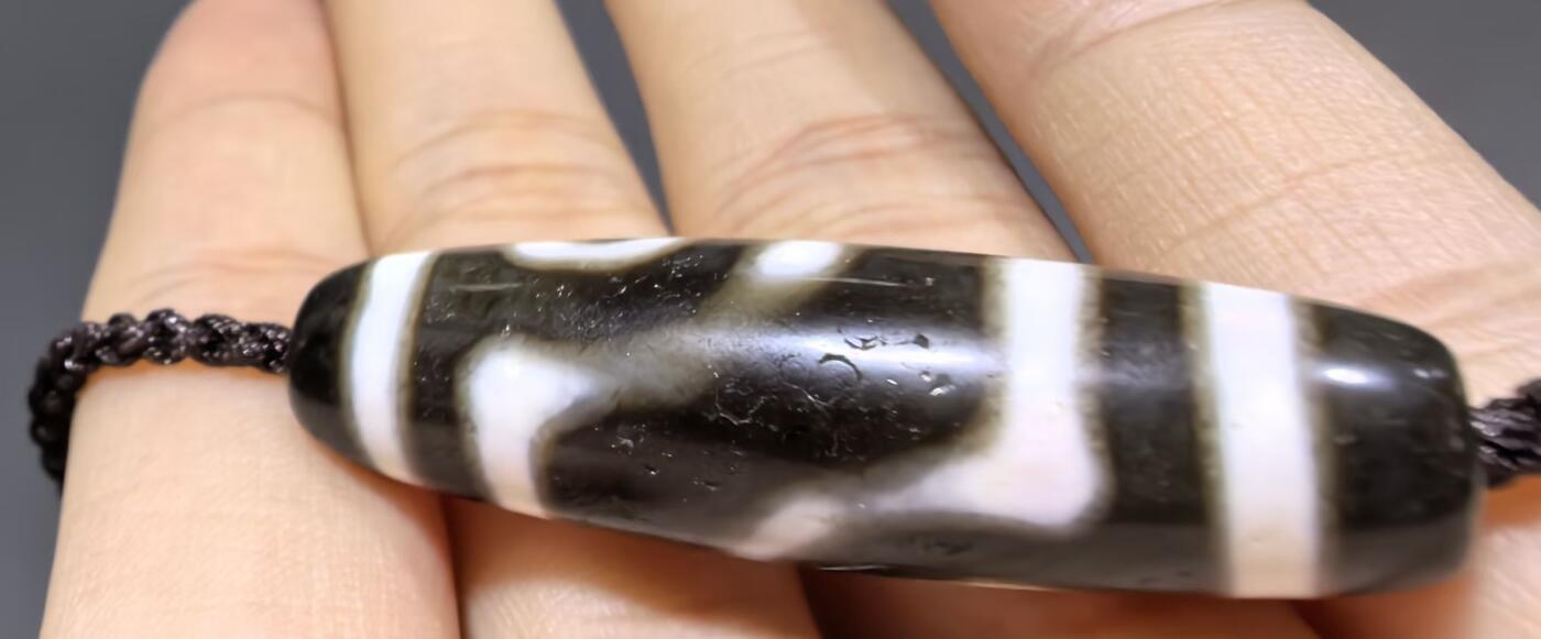 清末民国二眼天珠项链清末民国二眼天珠
此款二眼天珠是小年份大清至民国。可见明显的岁月包浆痕迹，珠体有明显的油沁，这是由于长时间佩戴，人体的油脂已经渗透到玛瑙里，产生了灰沁。
​尺寸:3.8*1.1cm
​