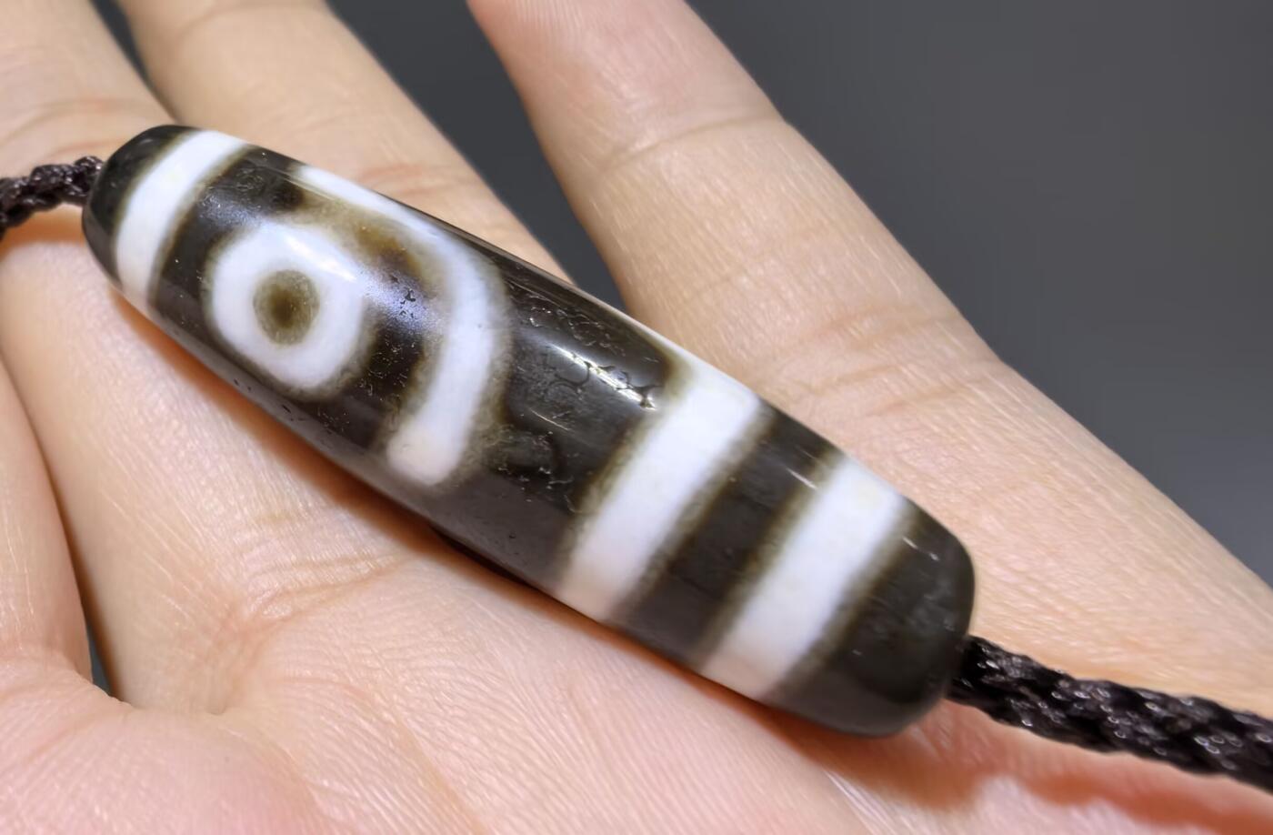 清末民国二眼天珠项链清末民国二眼天珠
此款二眼天珠是小年份大清至民国。可见明显的岁月包浆痕迹，珠体有明显的油沁，这是由于长时间佩戴，人体的油脂已经渗透到玛瑙里，产生了灰沁。
​尺寸:3.8*1.1cm
​