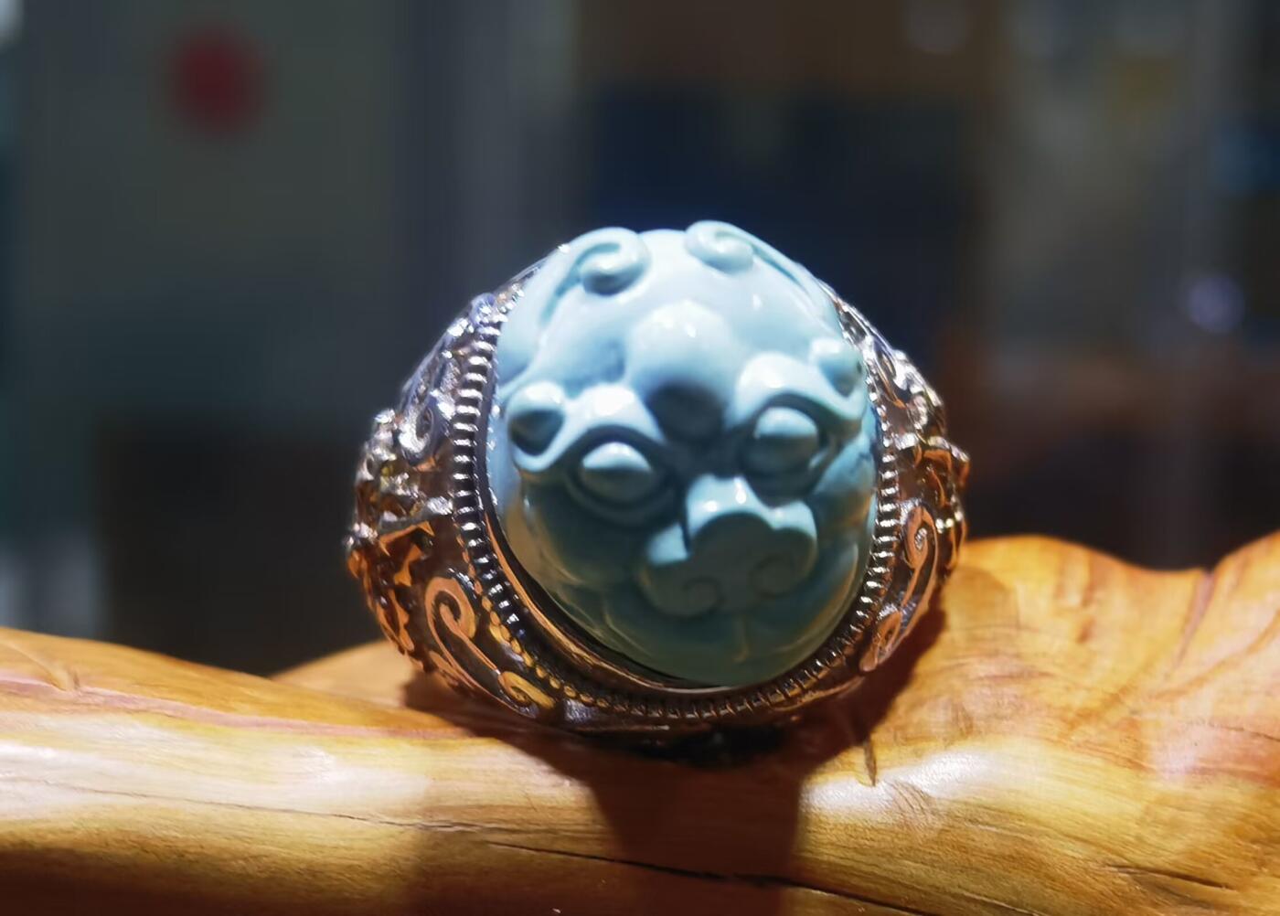 纯天然原矿松石雕刻兽面戒指男款，纯天然原矿松石能做雕刻要求瓷度密度比较高。松石瓷度不够，在雕刻的过程中容易松散，裸石干净漂亮。纯手工雕刻。霸气侧漏。尺寸:16mm×14mm*8mm纯银镂空镶嵌可调节指圈。