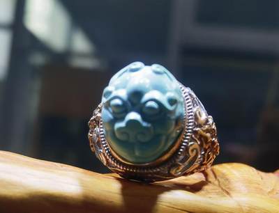 纯天然原矿松石雕刻兽面戒指男款，纯天然原矿松石能做雕刻要求瓷度密度比较高。松石瓷度不够，在雕刻的过程中容易松散，裸石干净漂亮。纯手工雕刻。霸气侧漏。尺寸:16mm×14mm*8mm纯银镂空镶嵌可调节指圈。