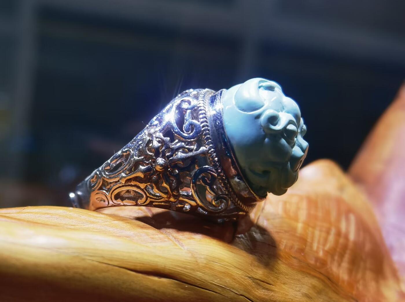 纯天然原矿松石雕刻兽面戒指男款，纯天然原矿松石能做雕刻要求瓷度密度比较高。松石瓷度不够，在雕刻的过程中容易松散，裸石干净漂亮。纯手工雕刻。霸气侧漏。尺寸:16mm×14mm*8mm纯银镂空镶嵌可调节指圈。