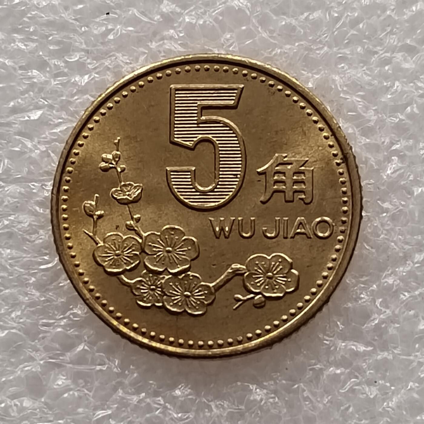 梅花五角硬币是中国第四套人民币中的辅币，1991年发行，2001年停铸，正面为梅花图案，背面为国徽及