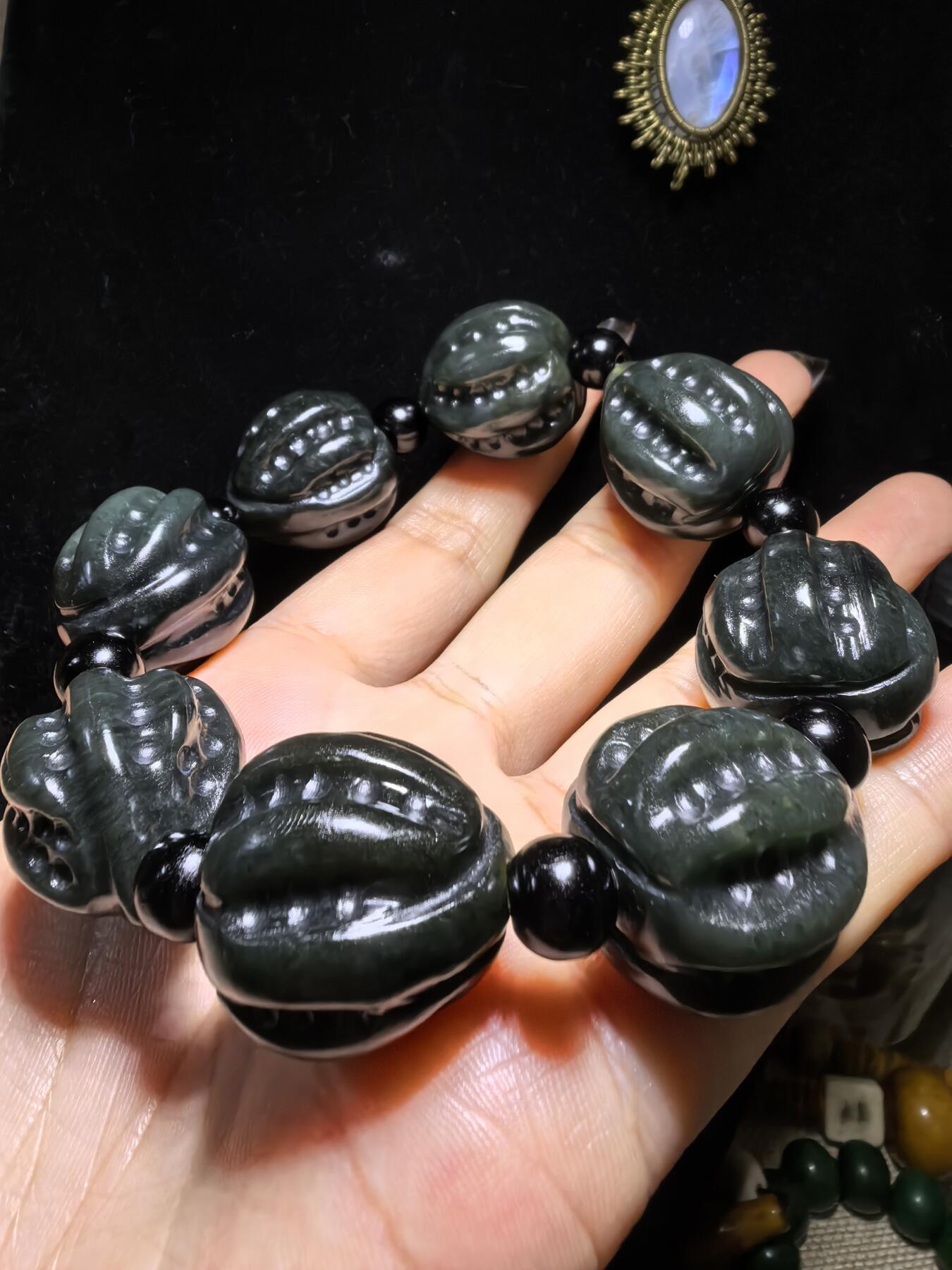 新疆和田黑青玉核桃手串，玉质油润细腻，脂粉十足，精雕细琢，霸气十足。尺寸：2.2cm*2.4cm克重：123g