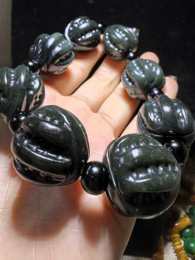 新疆和田黑青玉核桃手串，玉质油润细腻，脂粉十足，精雕细琢，霸气十足。尺寸：2.2cm*2.4cm克重：123g