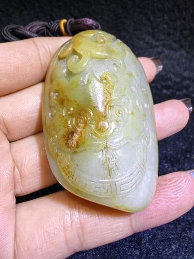 收藏级新疆喀什河籽料，府上有龙手把件男款，原籽洒金皮，可见天然毛孔撞击坑等。原皮原色，俏色巧雕寓意吉祥安康，尺寸：5.8cm*3.9cm**2.1cm
克重：75.2g自带国检证书！