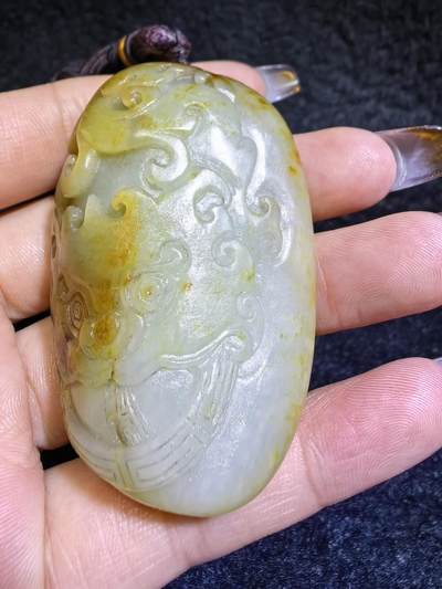 收藏级新疆喀什河籽料，府上有龙手把件男款，原籽洒金皮，可见天然毛孔撞击坑等。原皮原色，俏色巧雕寓意吉祥安康，尺寸：5.8cm*3.9cm**2.1cm
克重：75.2g自带国检证书！