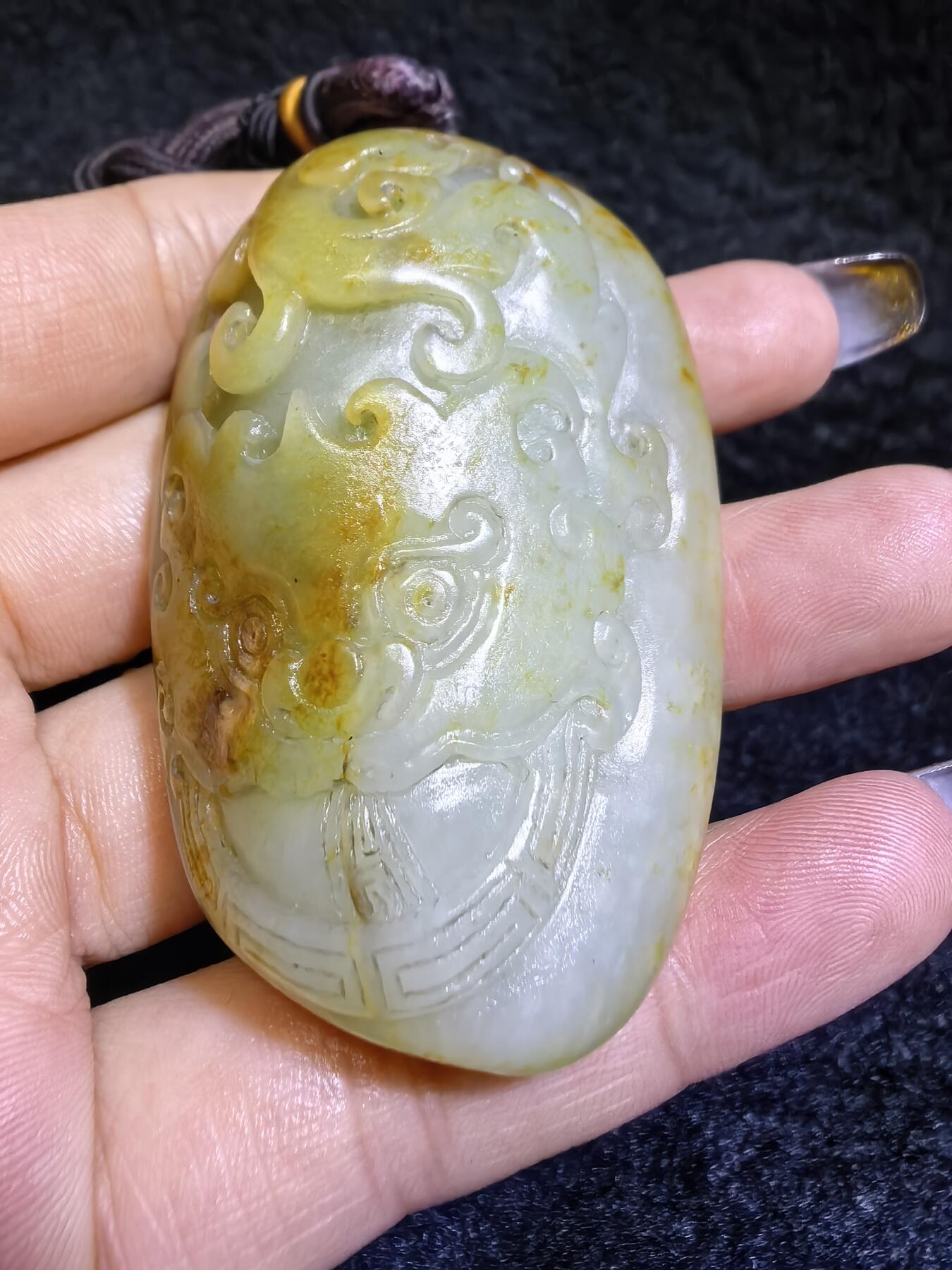 收藏级新疆喀什河籽料，府上有龙手把件男款，原籽洒金皮，可见天然毛孔撞击坑等。原皮原色，俏色巧雕寓意吉祥安康，尺寸：5.8cm*3.9cm**2.1cm
克重：75.2g自带国检证书！