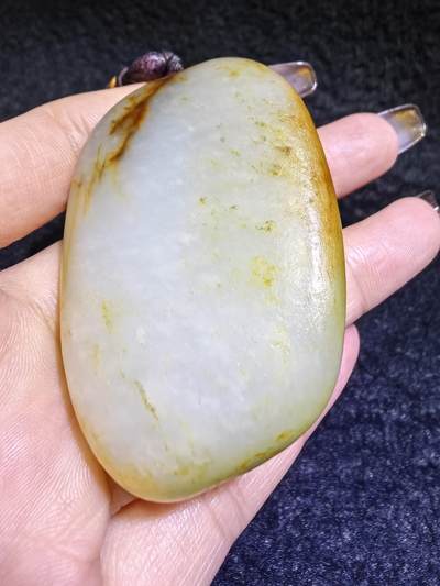 收藏级新疆喀什河籽料，府上有龙手把件男款，原籽洒金皮，可见天然毛孔撞击坑等。原皮原色，俏色巧雕寓意吉祥安康，尺寸：5.8cm*3.9cm**2.1cm
克重：75.2g自带国检证书！