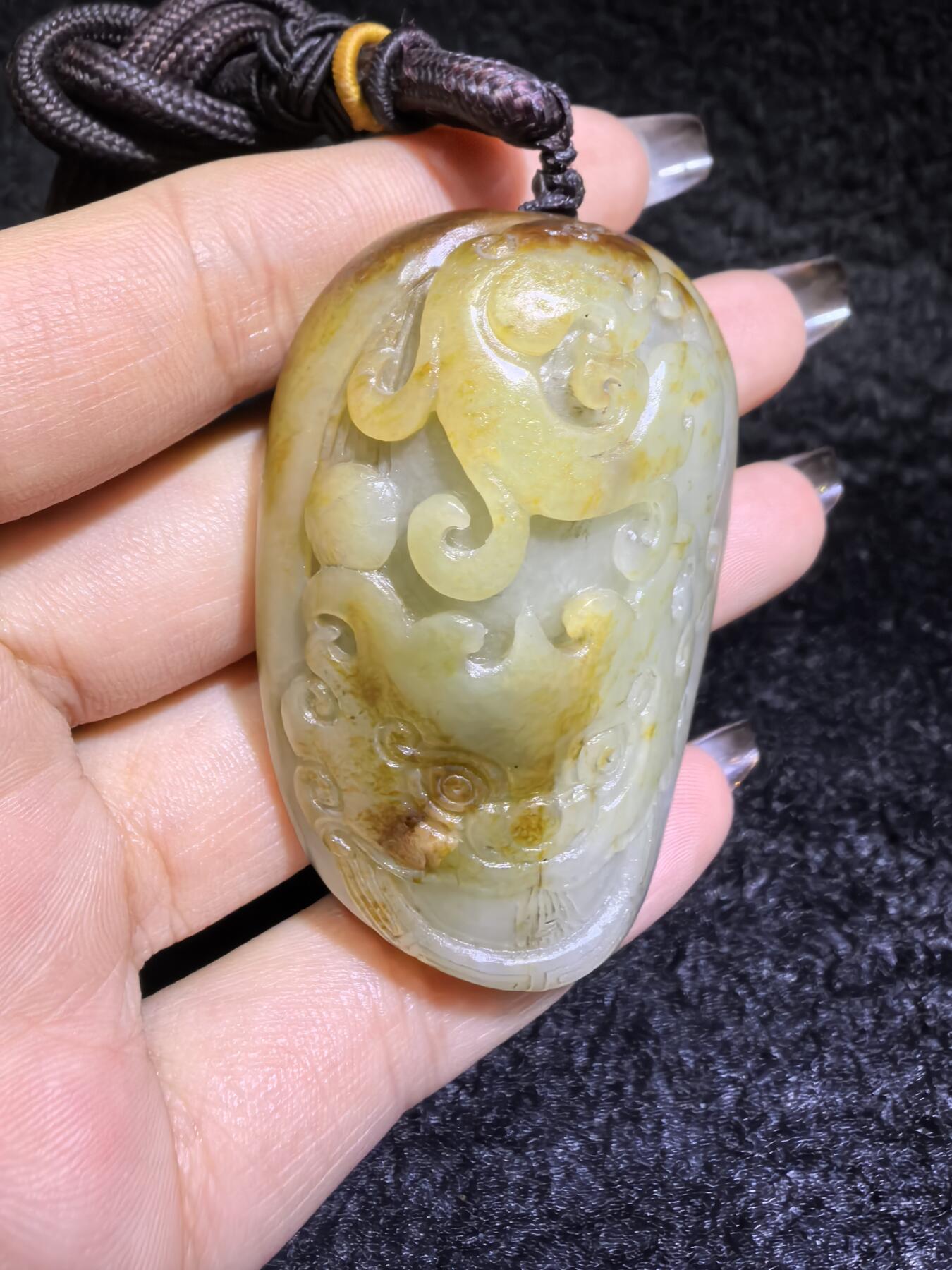 收藏级新疆喀什河籽料，府上有龙手把件男款，原籽洒金皮，可见天然毛孔撞击坑等。原皮原色，俏色巧雕寓意吉祥安康，尺寸：5.8cm*3.9cm**2.1cm
克重：75.2g自带国检证书！